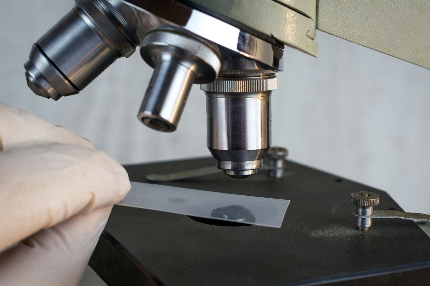 Person examining a sample under a microscope